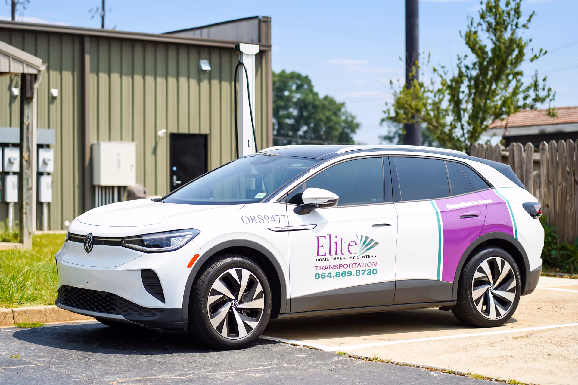 White van with Elite Home Care and Day Centers branding parked beside a building.