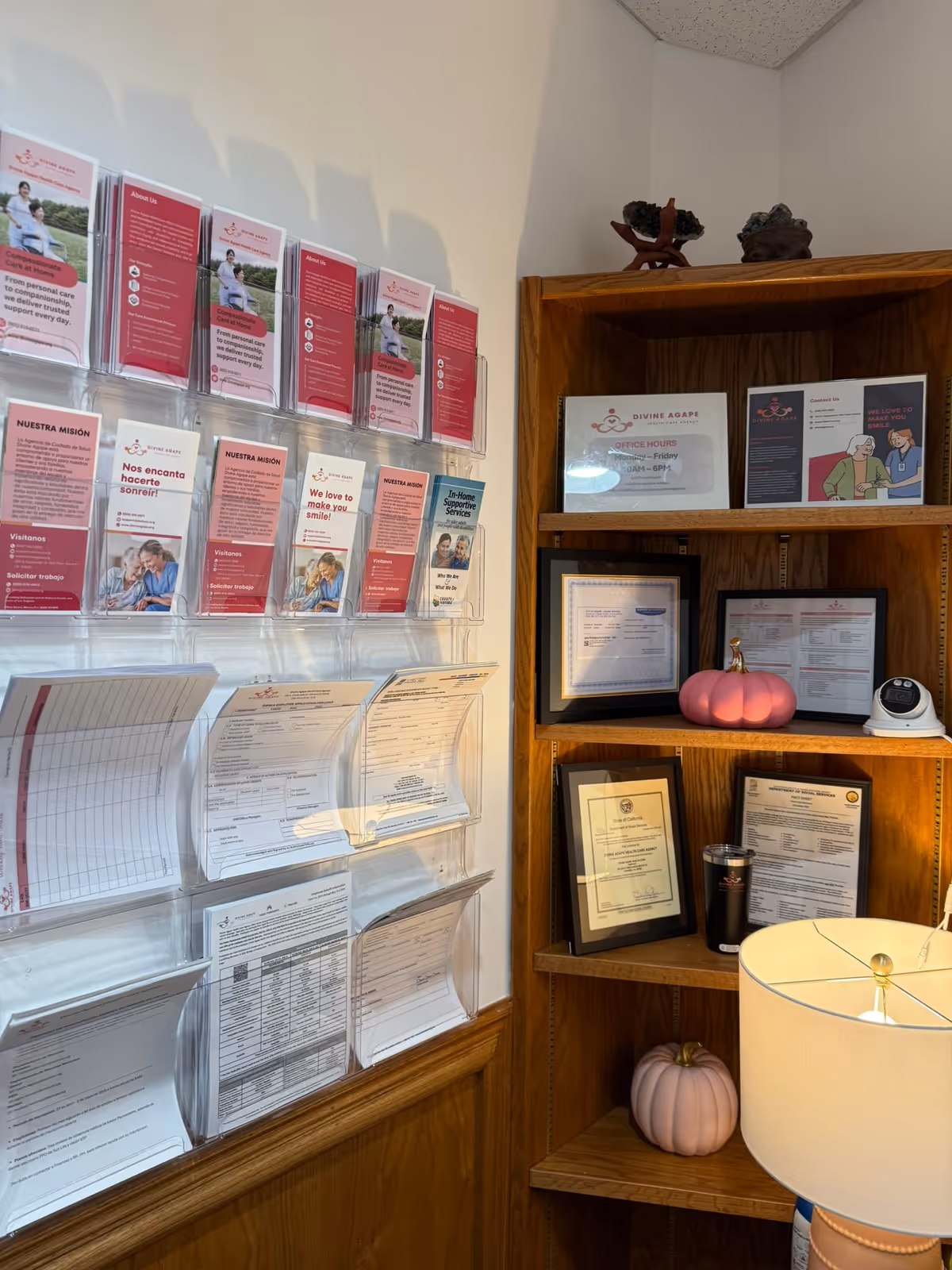 Interior lobby area with brochure racks, wooden shelving, certificates, and decorative pink pumpkins.
