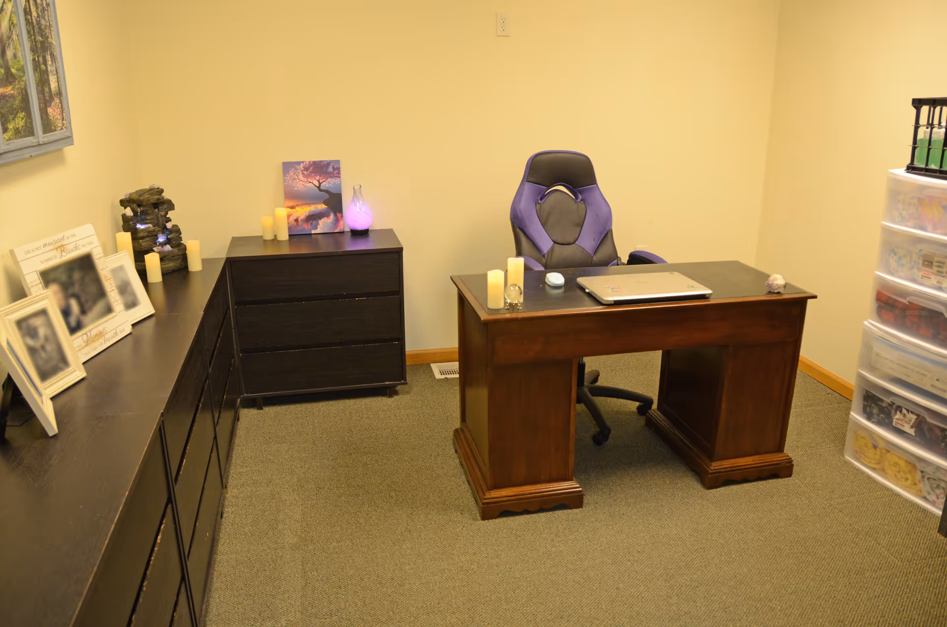 Home office with dark wood desk, purple chair, and storage drawers.