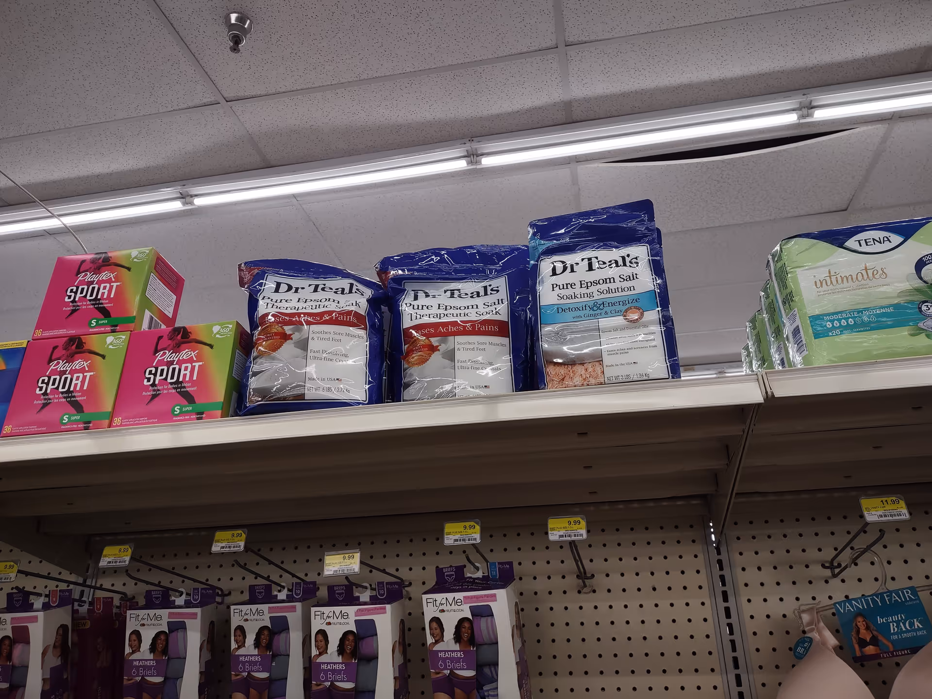 A store shelf of health products with Dr Teal's salts and Playtex Sport boxes.