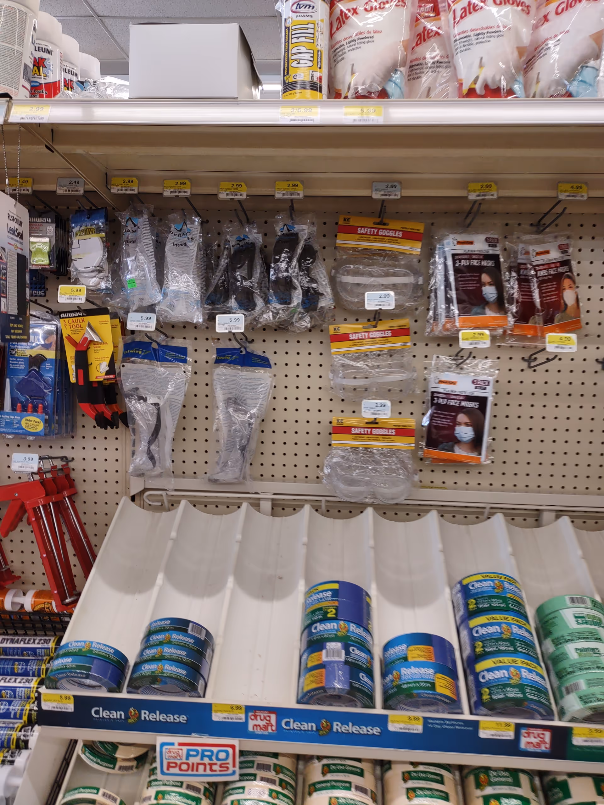 Store aisle with PPE and cleaning products on pegboard shelves.