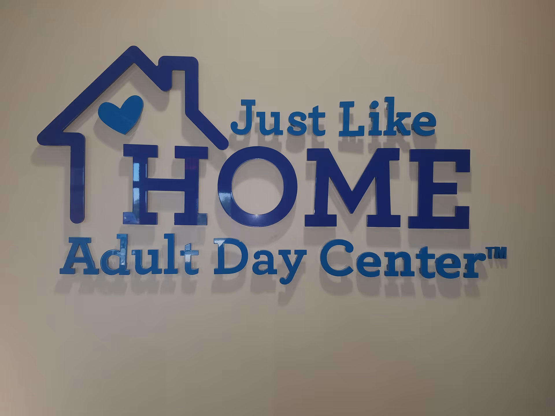 Interior wall features a large 'Just Like HOME Adult Day Center' sign.