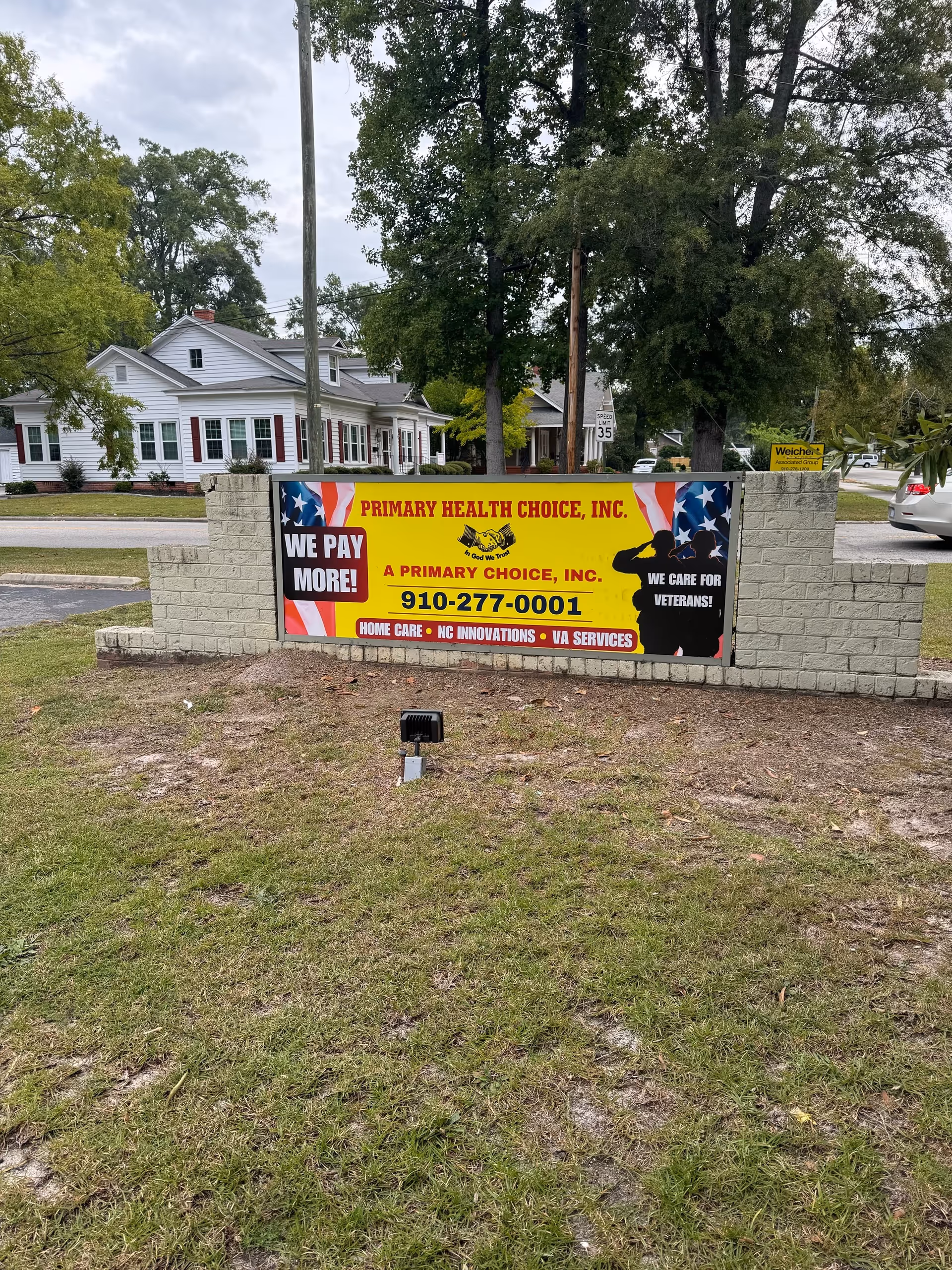 Outdoor sign for Primary Health Choice on a brick wall in front yard