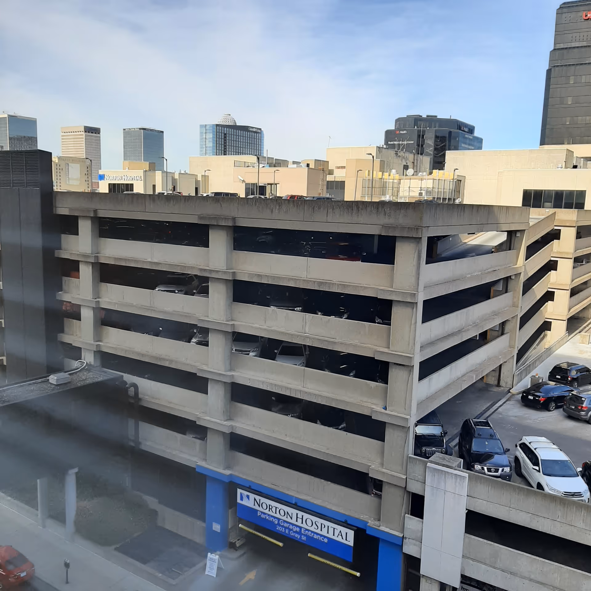 View of a multi-level parking garage with Norton Hospital signage and city skyline.