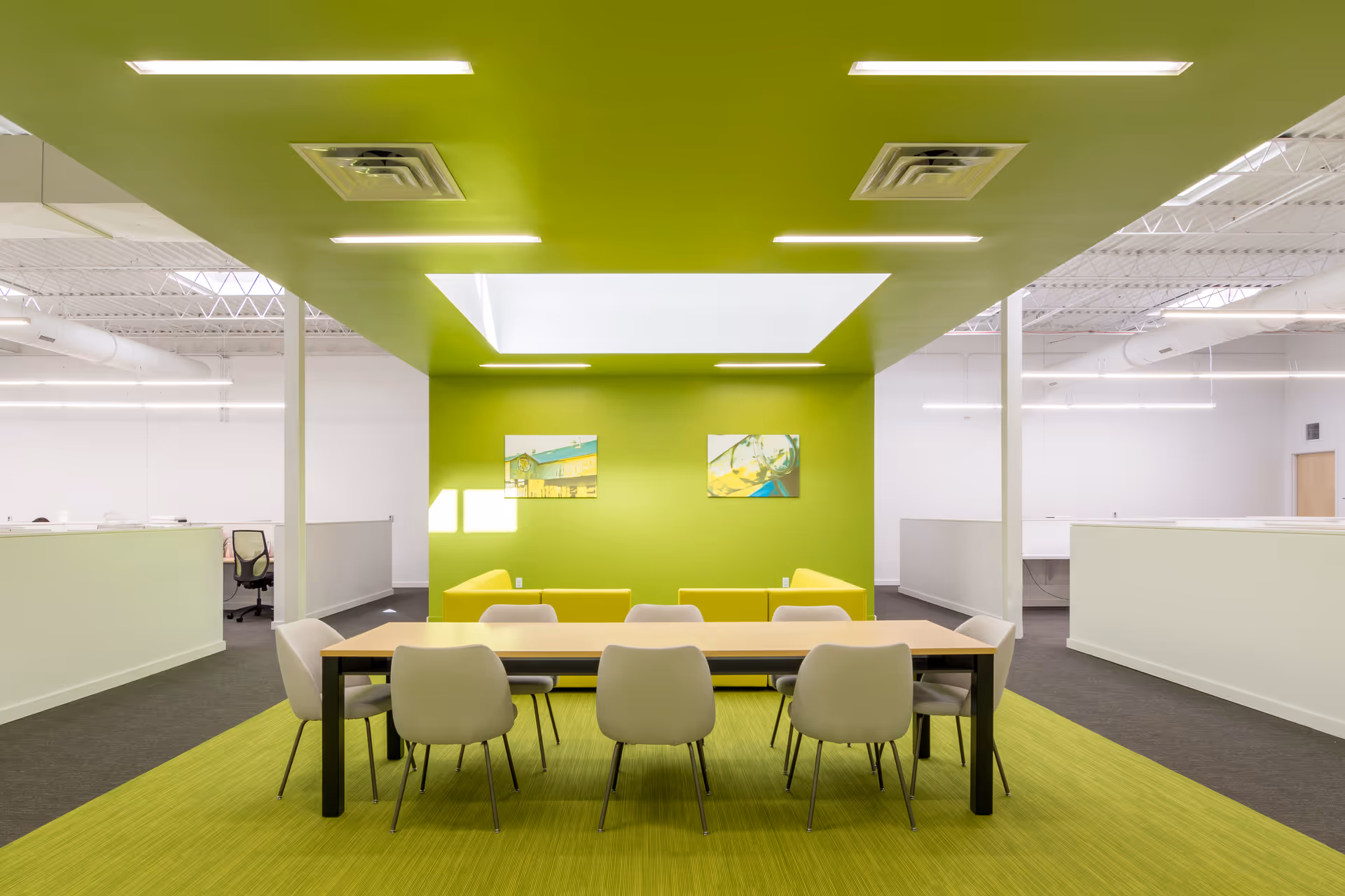 Bright dining area with lime-green accents, a long table, and white chairs.