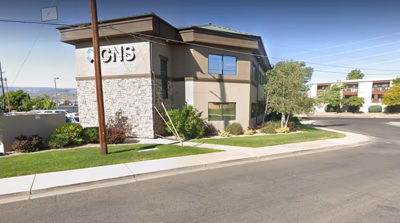 Front exterior view of a modern senior living facility with landscaped entrance.