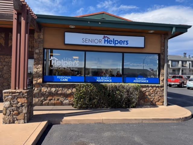 Exterior view of a Senior Helpers storefront with stone facade and large windows.