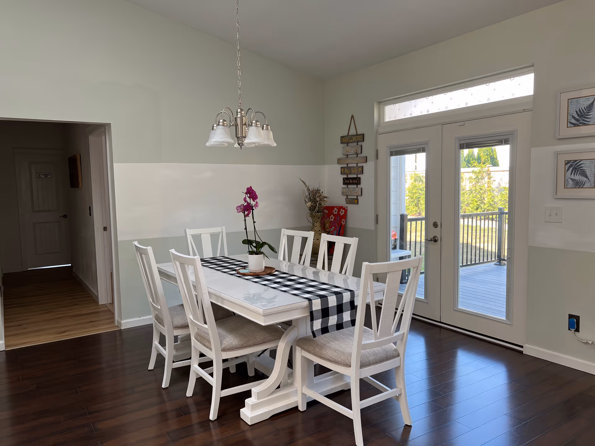 Bright dining room in a senior living home with white table, chairs, and checkered runner.