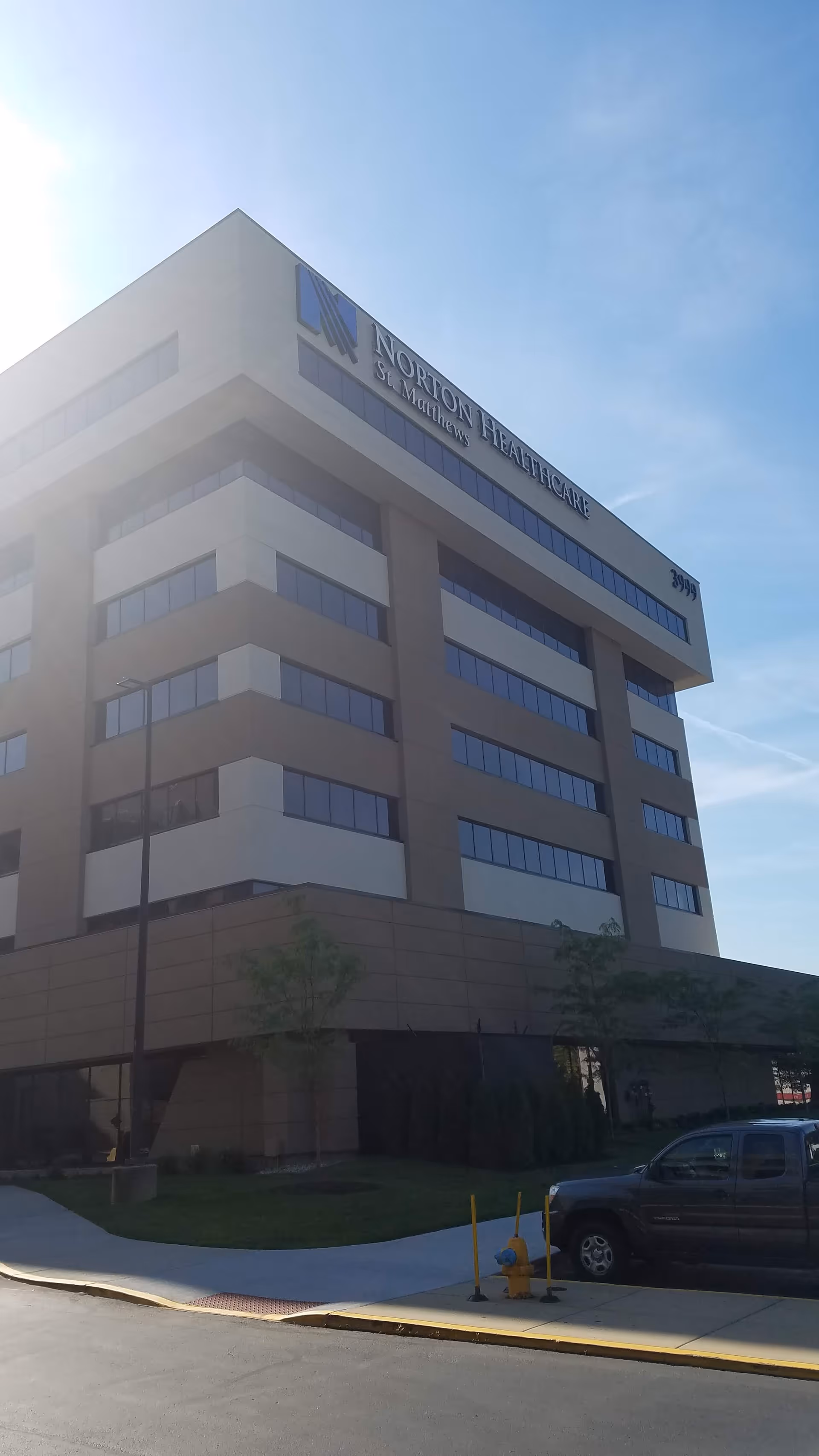 Tall beige Norton St. Matthews Medical Plaza 1 building exterior under a clear blue sky.