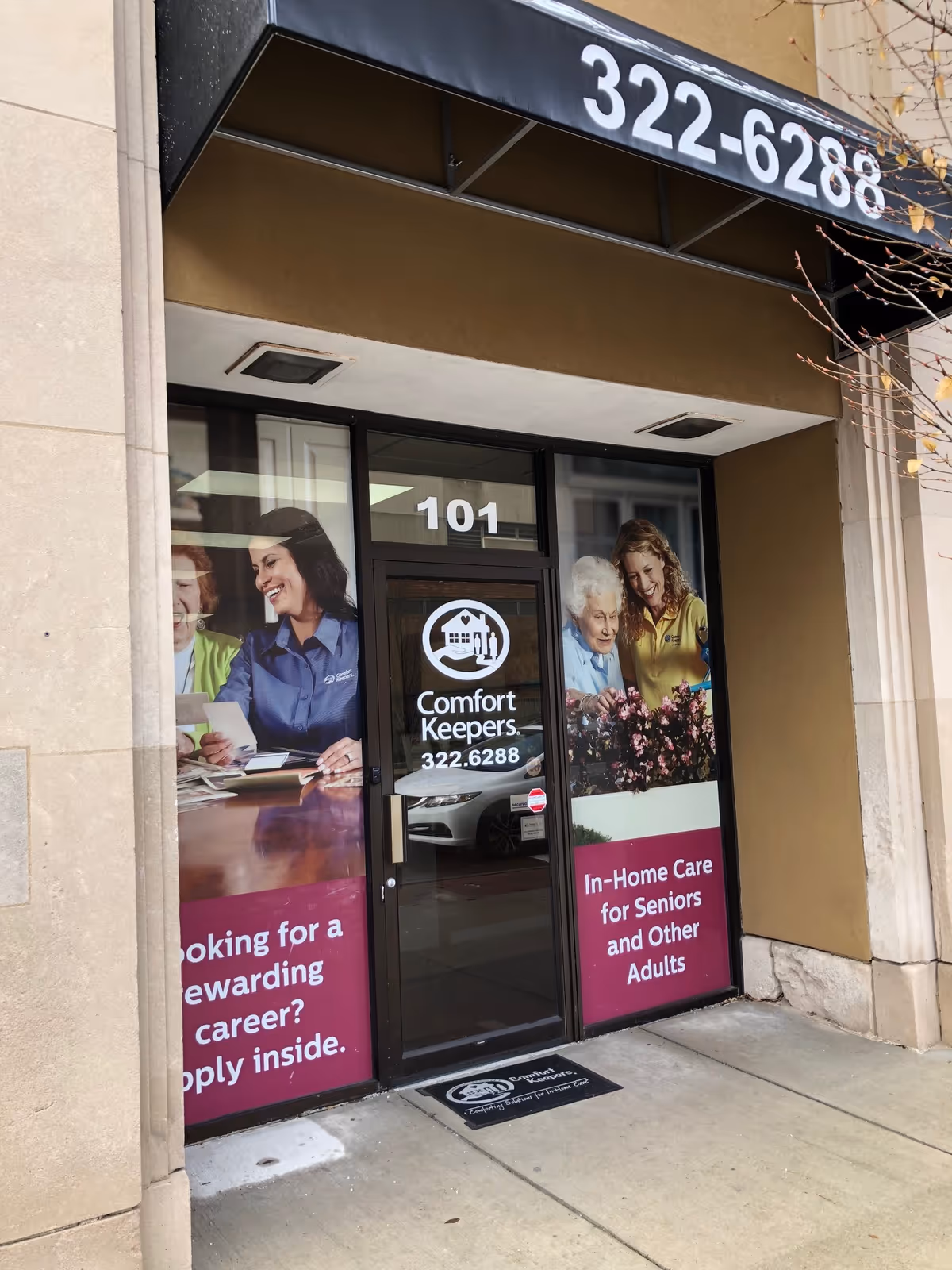 Storefront entrance for Comfort Keepers Home Care with signage and resident imagery.