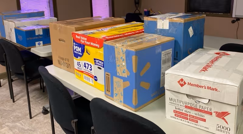 A room in Absolute Care Management with boxed supplies on a table.