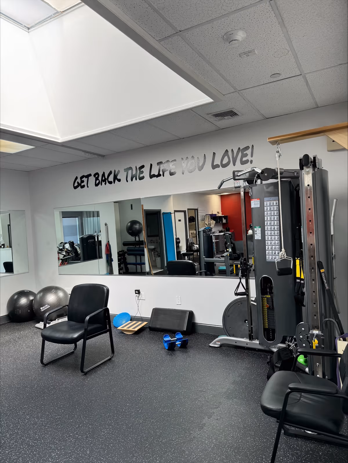 Small gym in a senior facility with fitness equipment and a motivational slogan.
