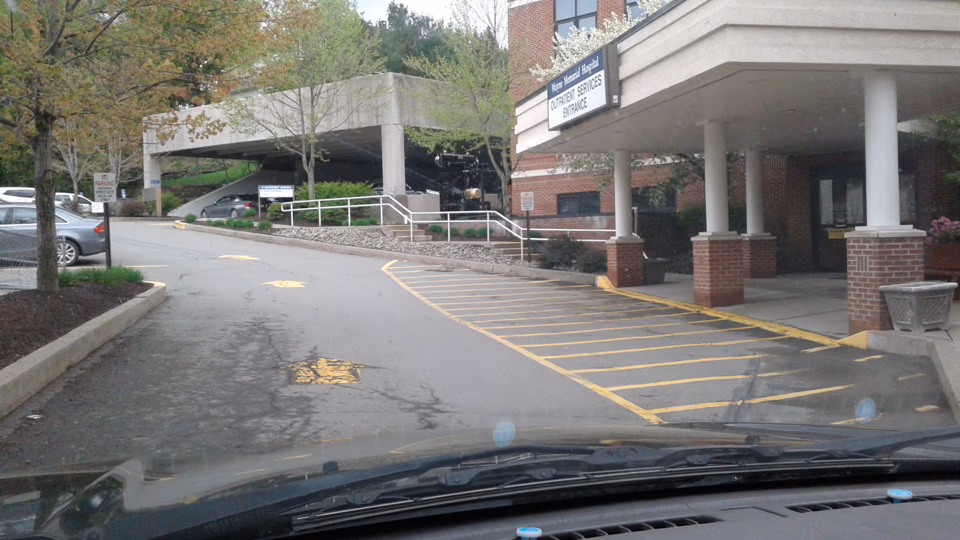 Exterior view of Wayne Memorial Hospital entrance with a covered drop-off and parking area.