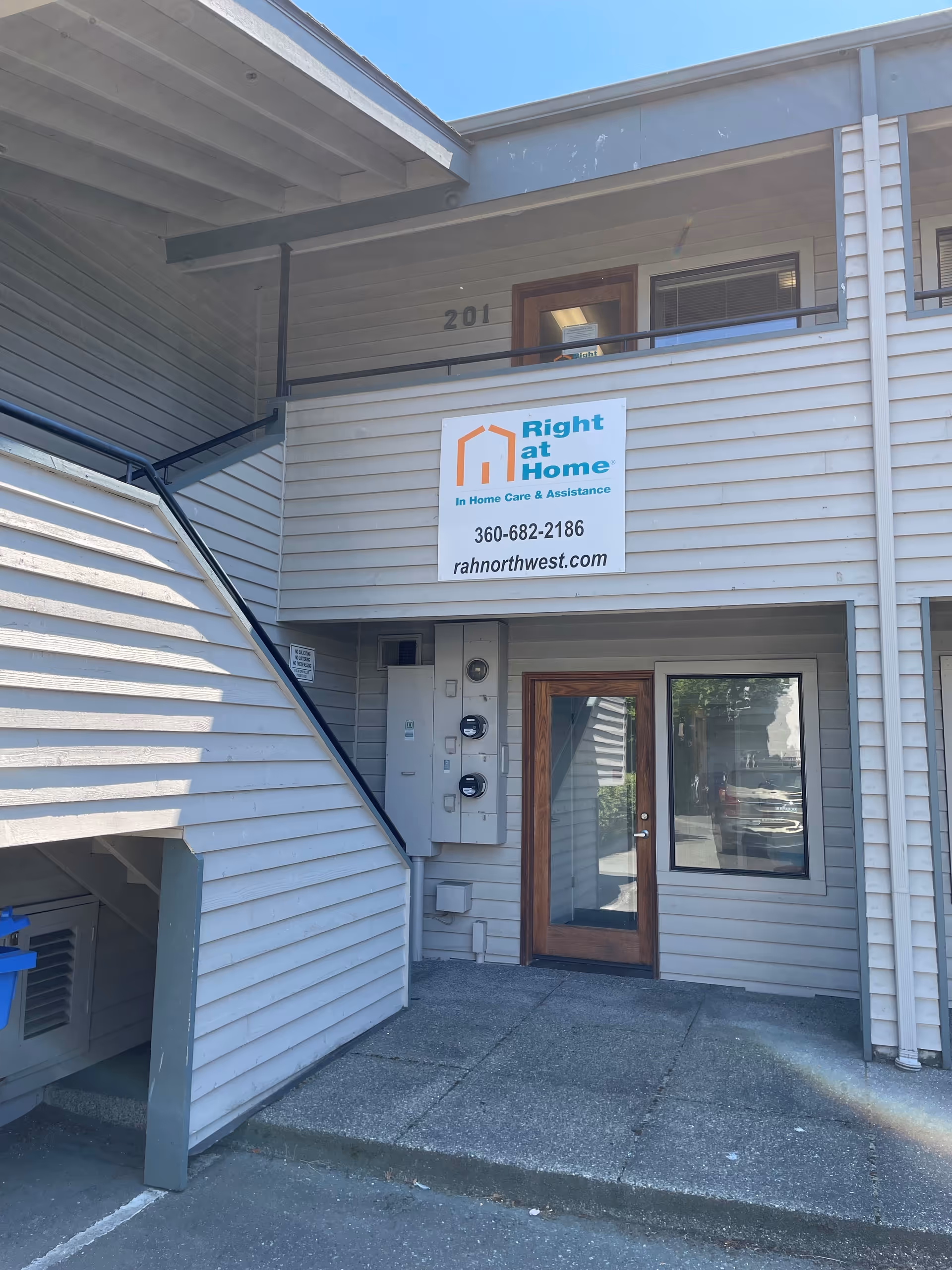Exterior view of a two-story building entrance with a Right at Home sign