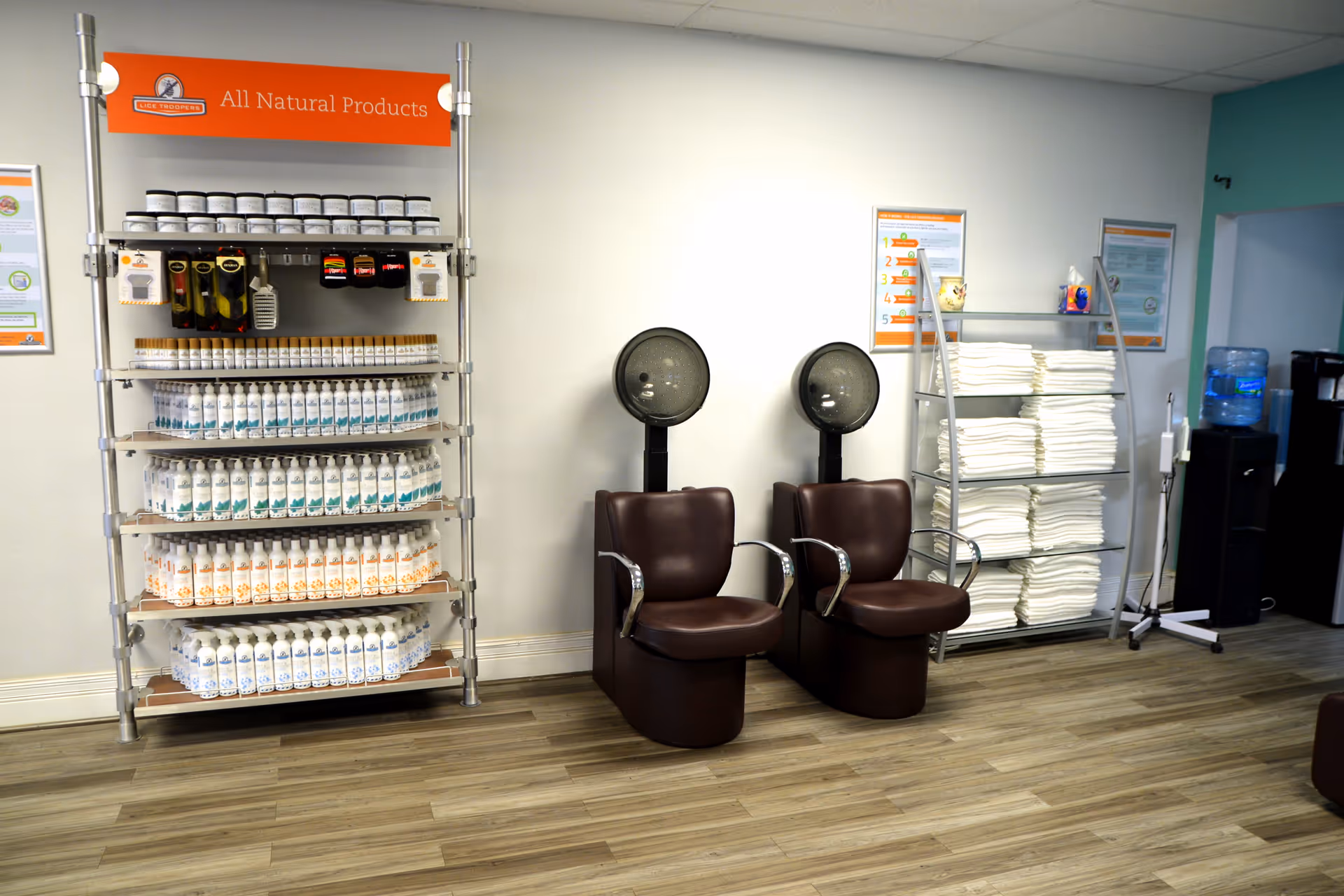 Interior room with product shelves, stacked towels, and two brown chairs.