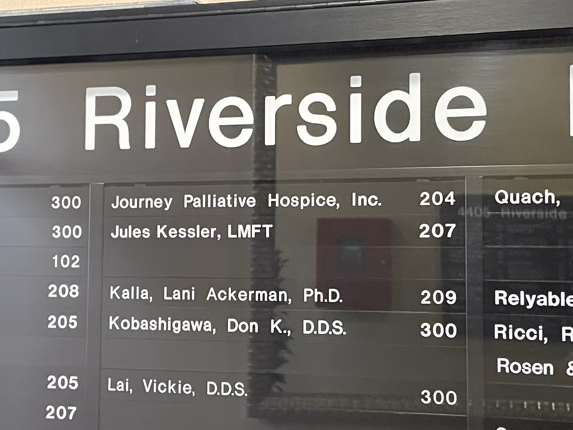 Interior directory board listing Journey Palliative Hospice, Inc. with room numbers and staff names.