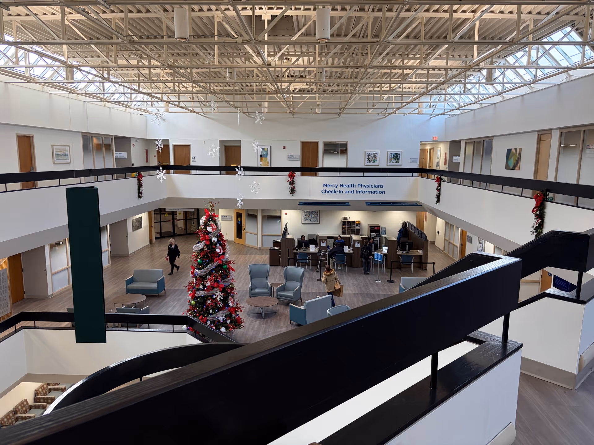 A large hospital lobby atrium with a Christmas tree, seating, and check-in desks.