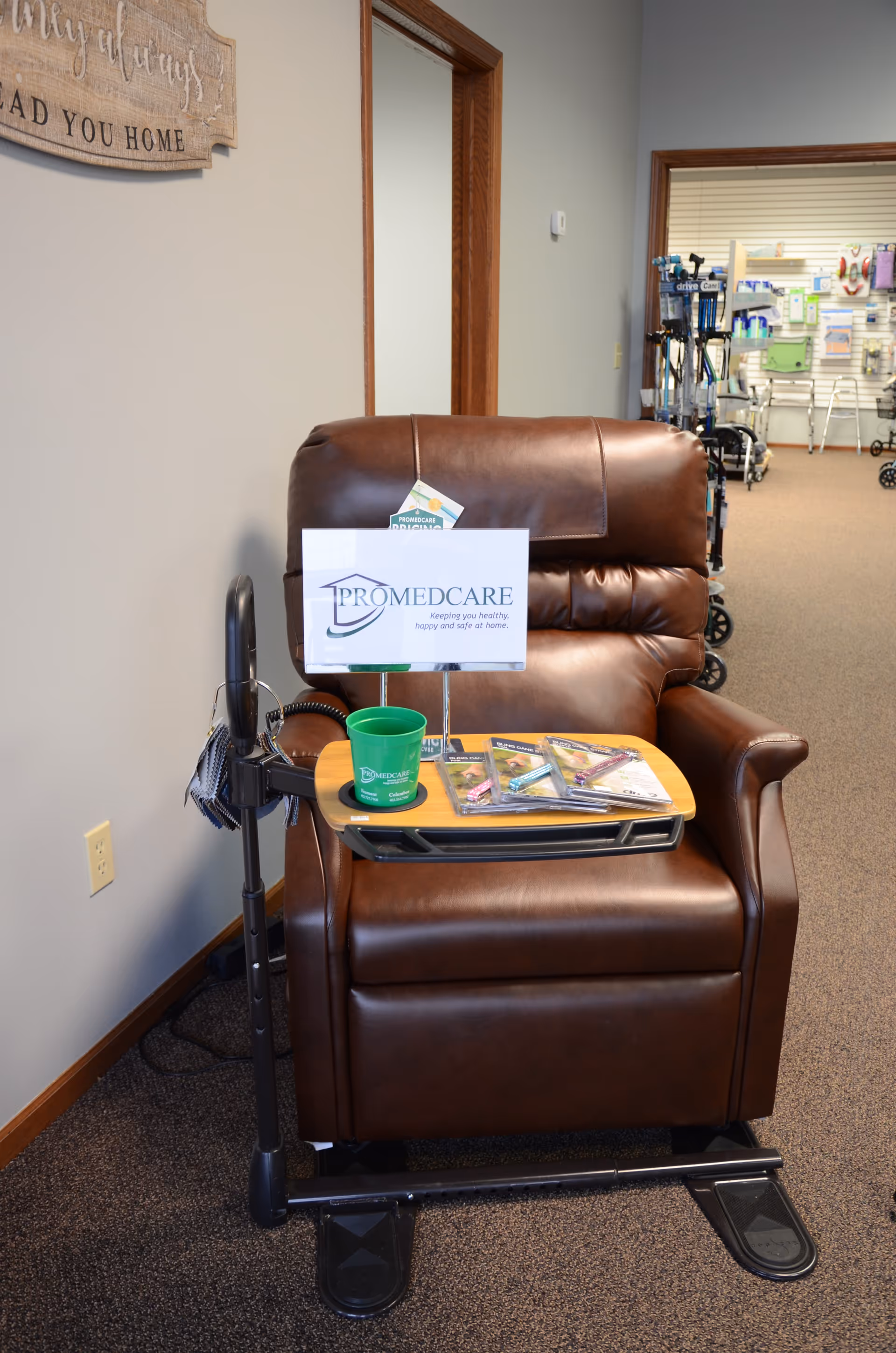 Brown leather recliner with a Promedcare sign and pamphlets in a facility lobby.
