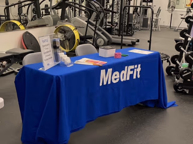 An indoor fitness area featuring a blue MedFit table and exercise equipment.
