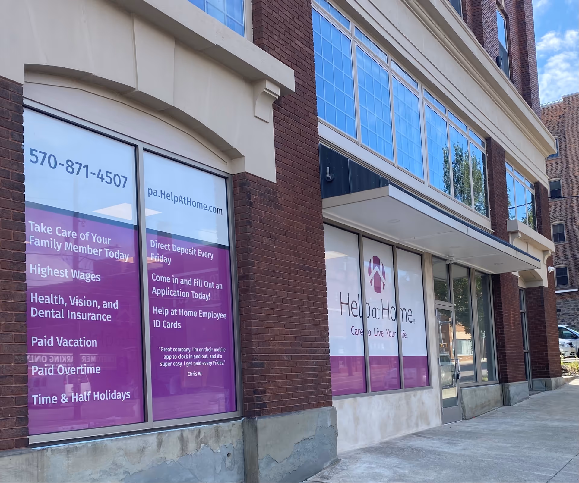 Exterior view of Help at Home facility storefront with purple banners