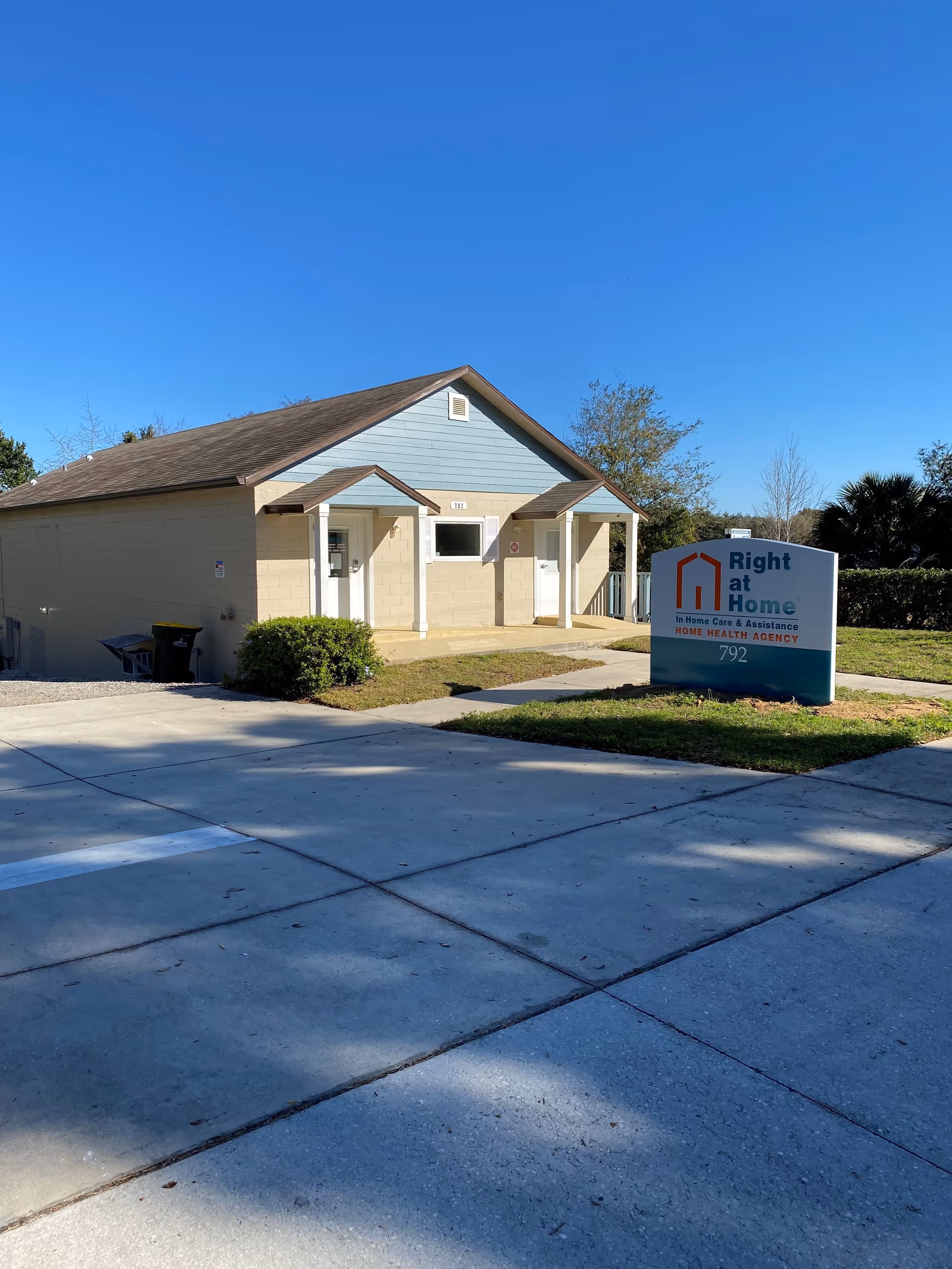 Sunny exterior view of a single-story Right at Home facility with entrance.
