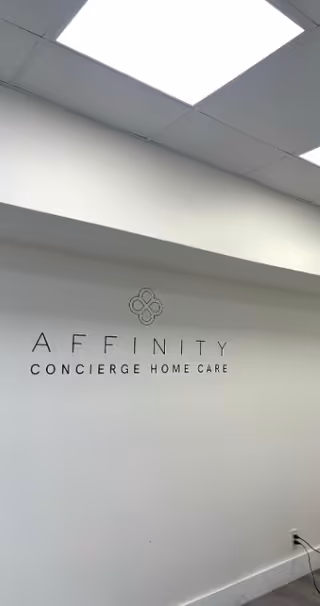 White interior wall with Affinity Concierge Home Care sign and ceiling lights.