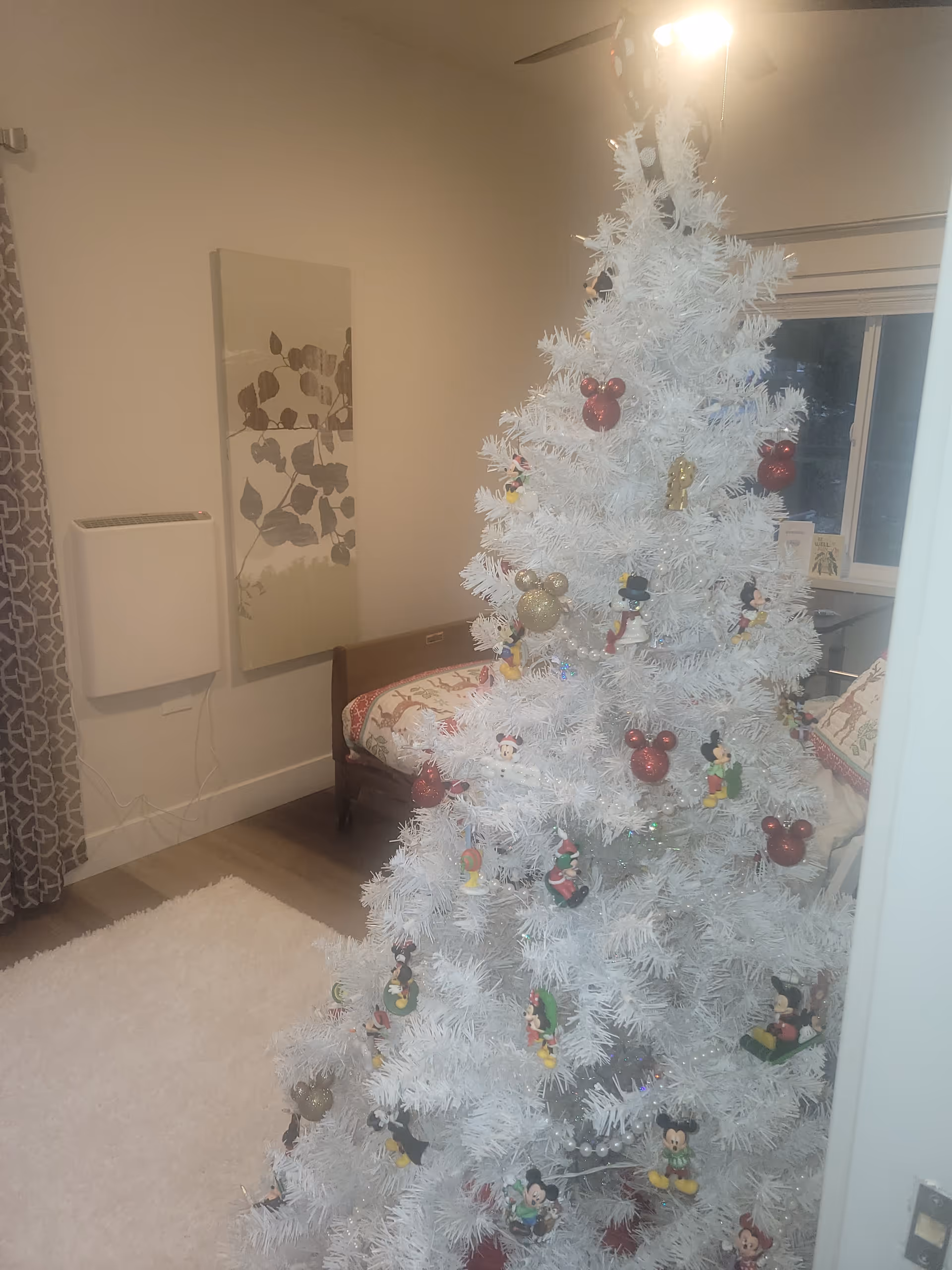 White Christmas tree decorates a cozy living room in a senior living facility.
