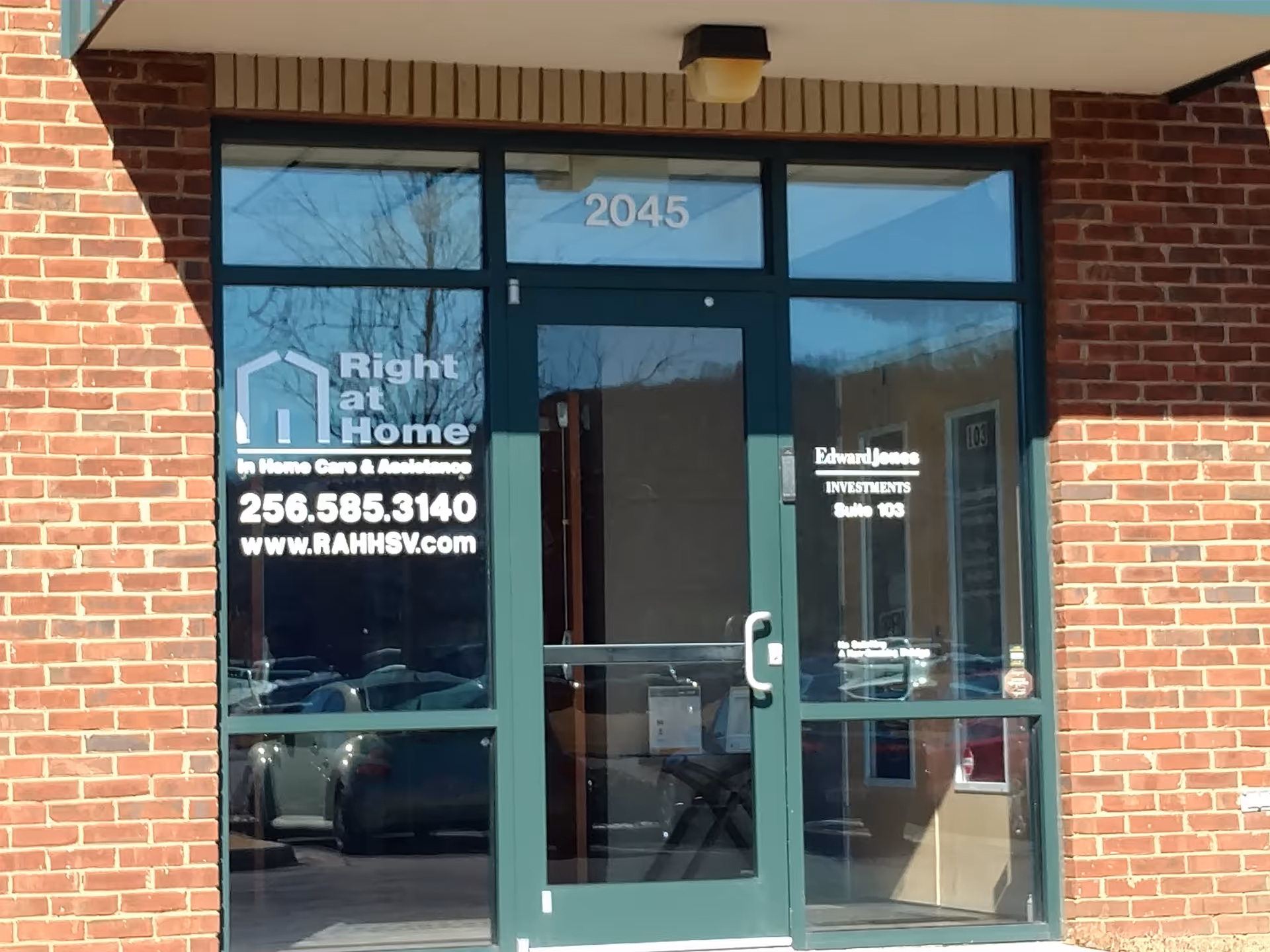 Brick building entrance with glass doors and Right at Home signage.