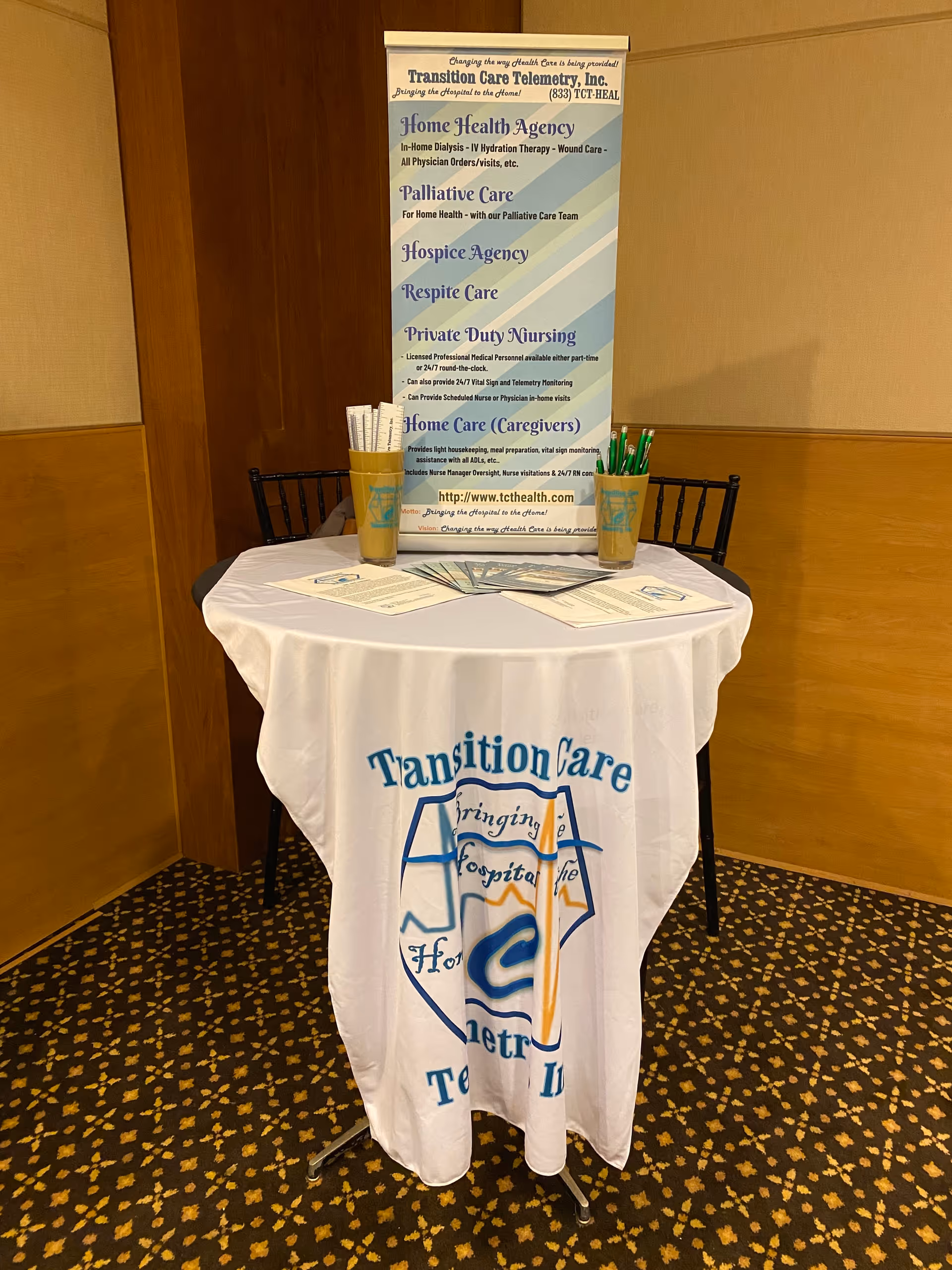 Promotional display table with banner and pens for Transition Care Telemetry, Inc.