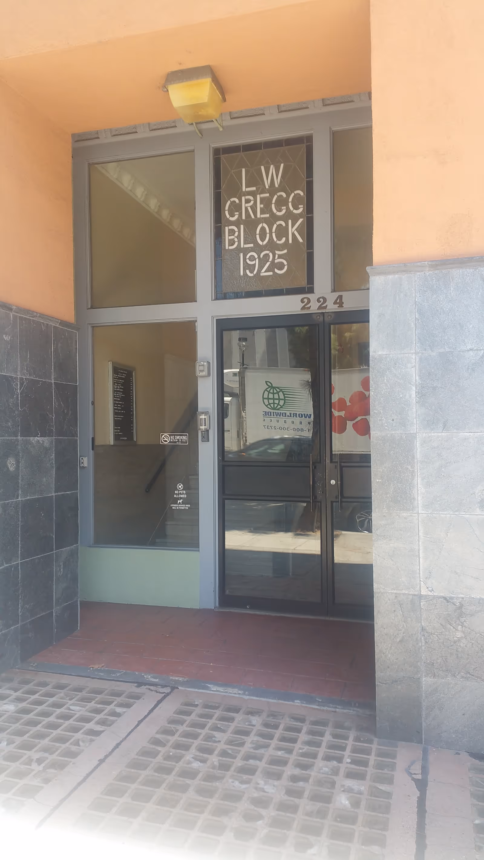 Exterior entrance to a building with glass doors and orange walls.