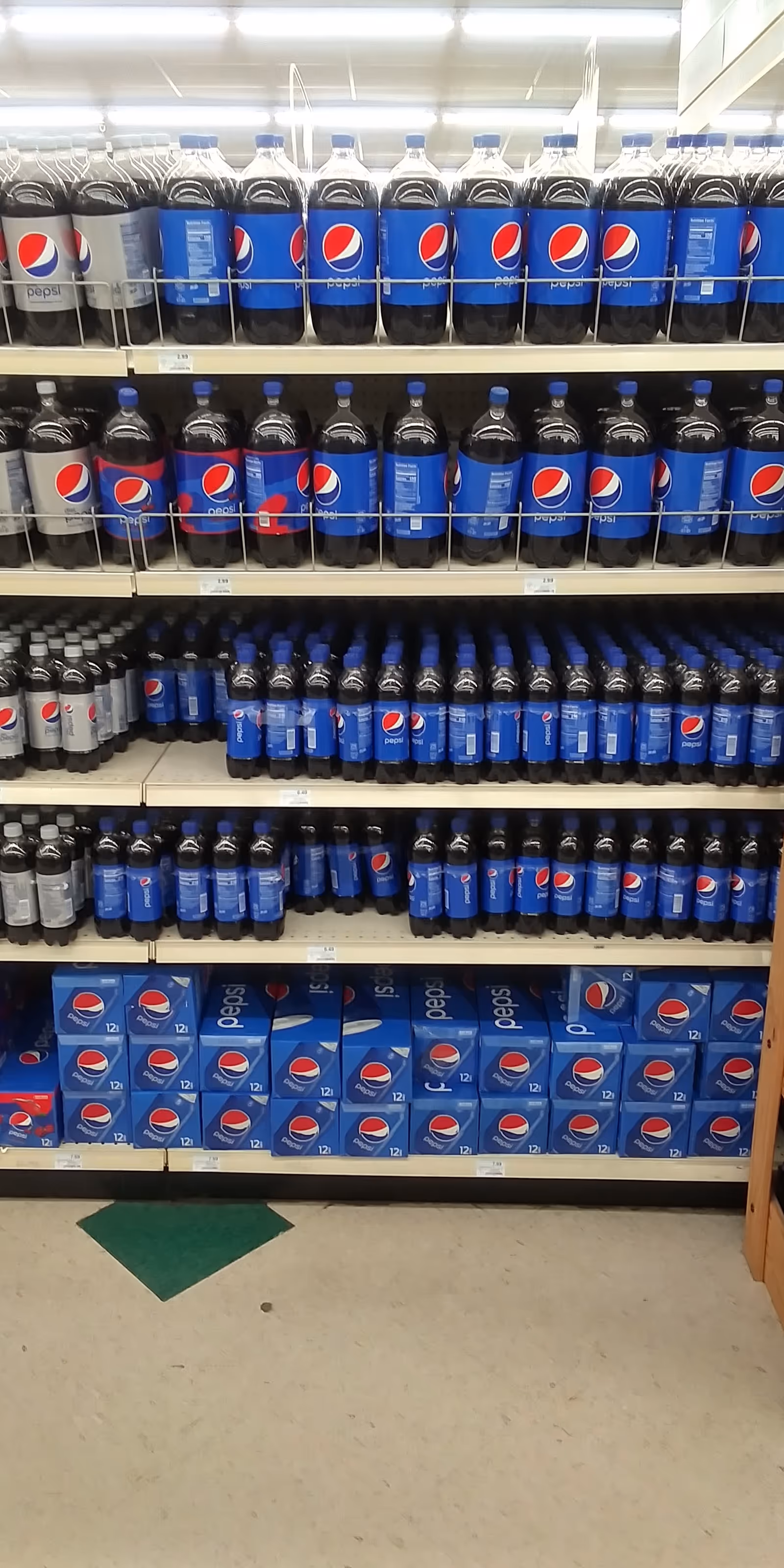 Shelves filled with Pepsi bottles and boxes in a Discount Drug Mart aisle.