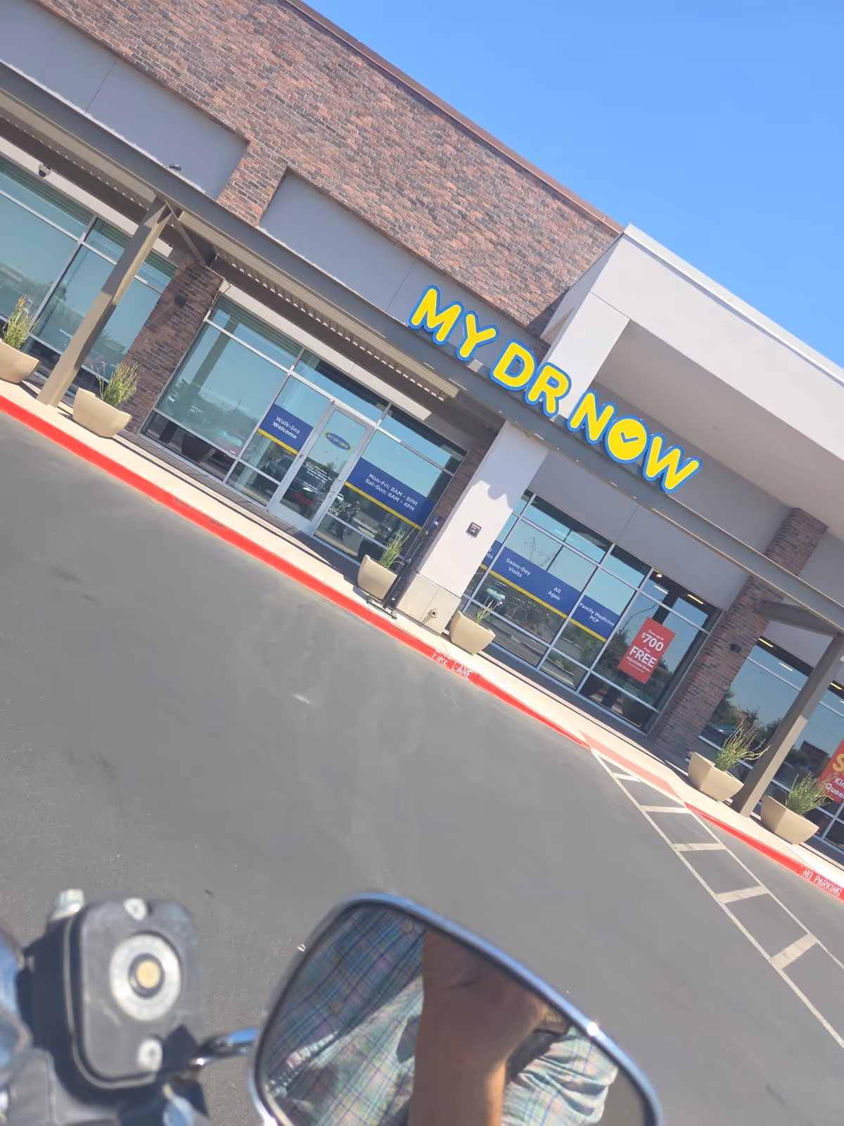 Exterior view of a building with a bright MY DR NOW sign and glass storefront.