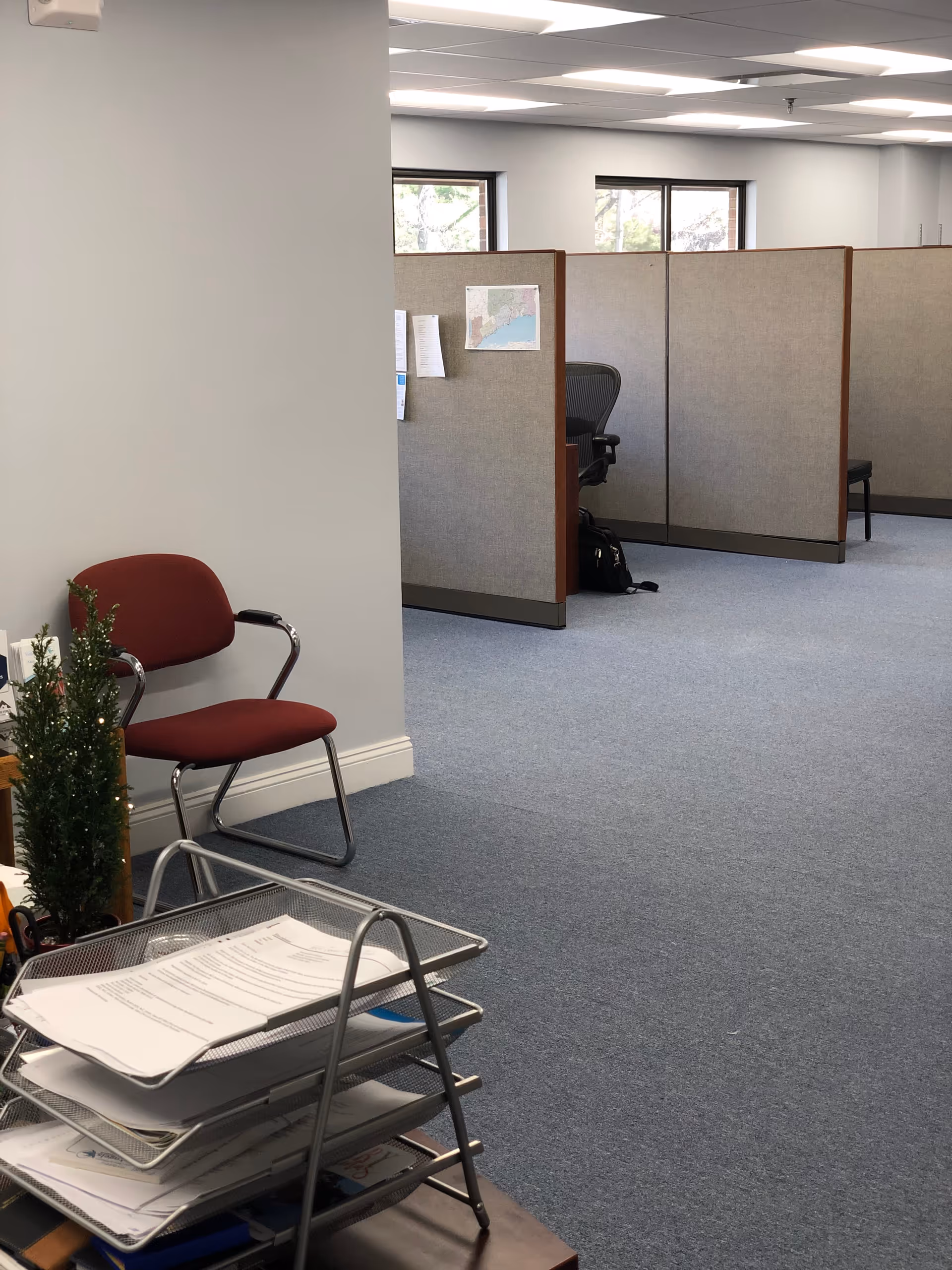 Office area with cubicles, chairs, and a rolling file cart.