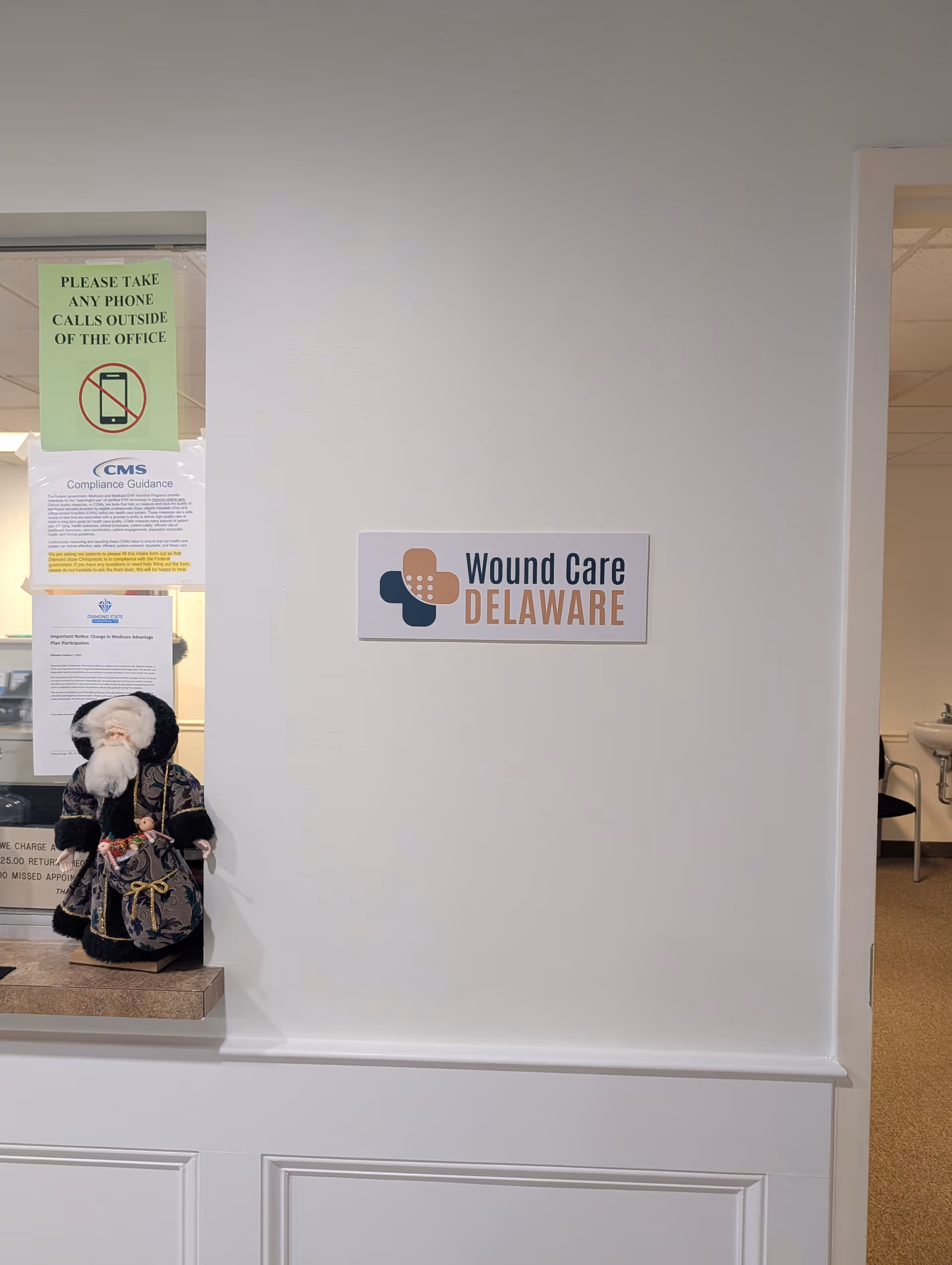 Interior hallway with a 'Wound Care Delaware' sign and a Santa doll on a counter.