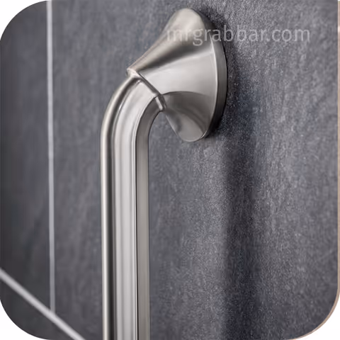 Close-up of a stainless steel bathroom grab bar mounted on a dark tiled wall.