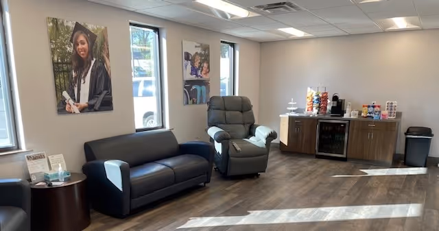 Senior living facility lounge with sofa, recliner, and beverage station.