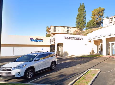 Exterior view of a Senior Helpers facility with a white SUV parked in front.