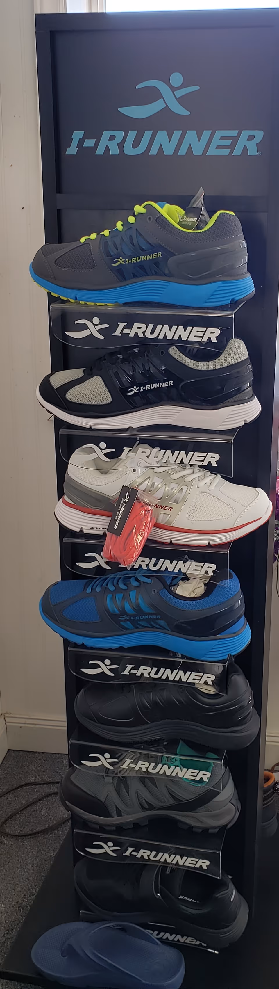 Indoor shoe display rack featuring multiple I-RUNNER running shoes.