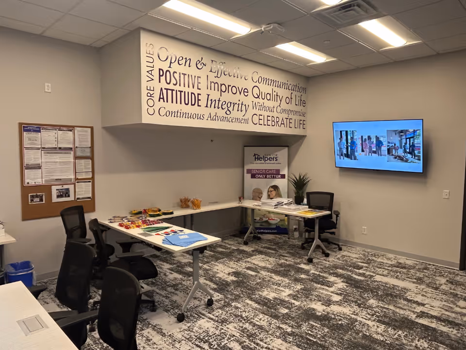 Office reception area of Senior Helpers with desks and wall signage.