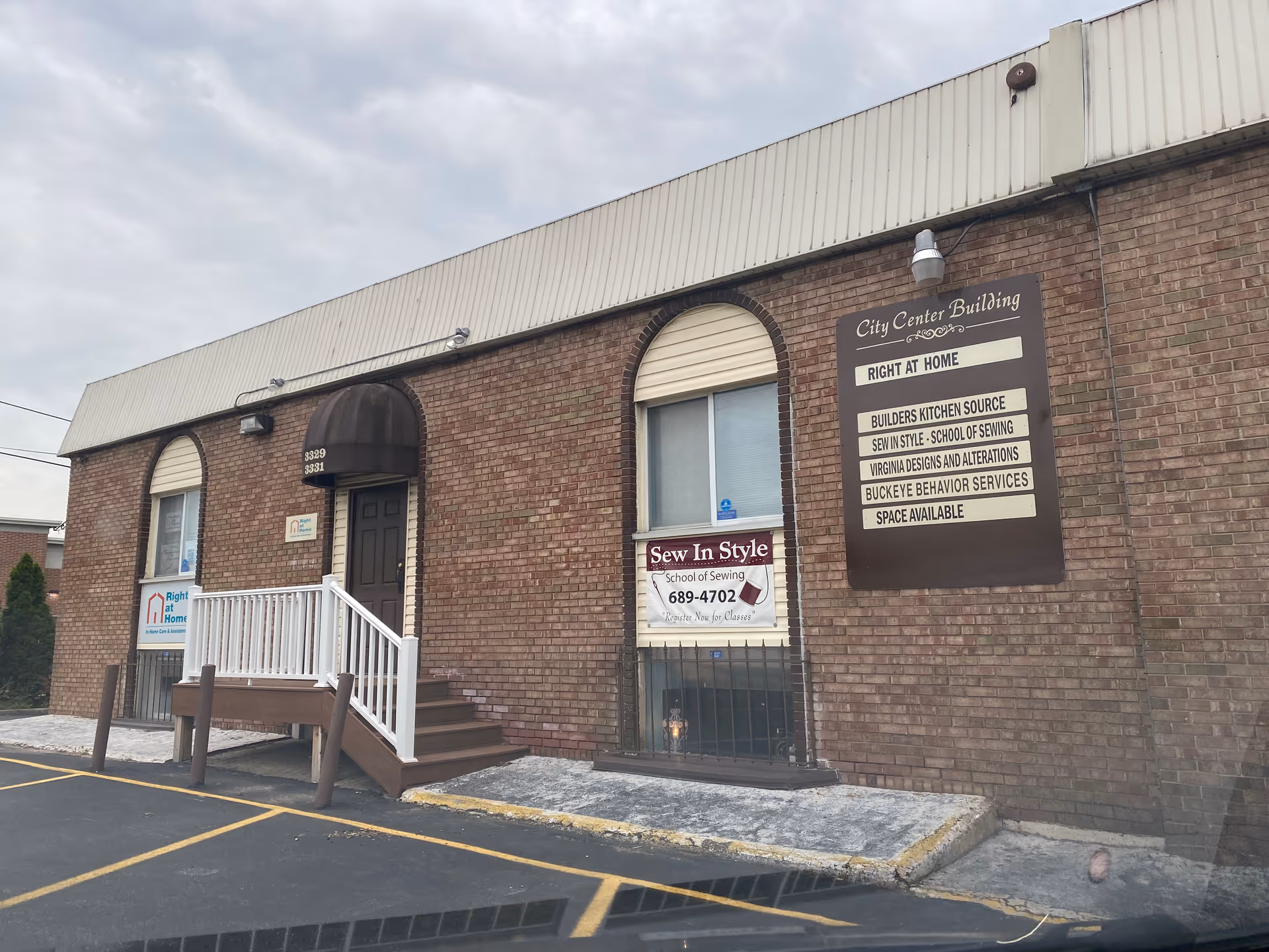 Brick building storefront with stairs, ramp, and signs including Right at Home on the front.
