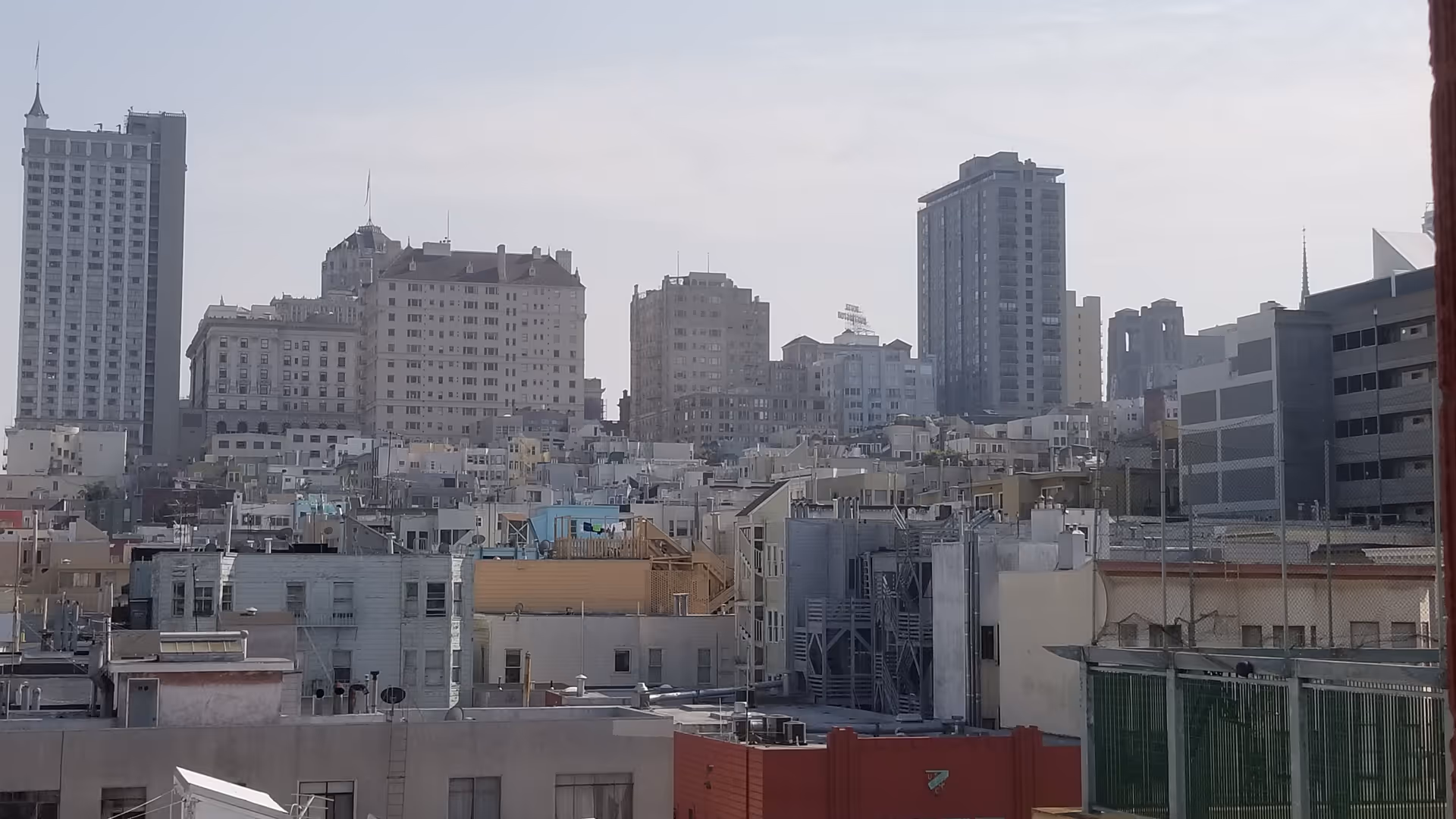 City skyline with numerous high-rise buildings and densely packed rooftops.