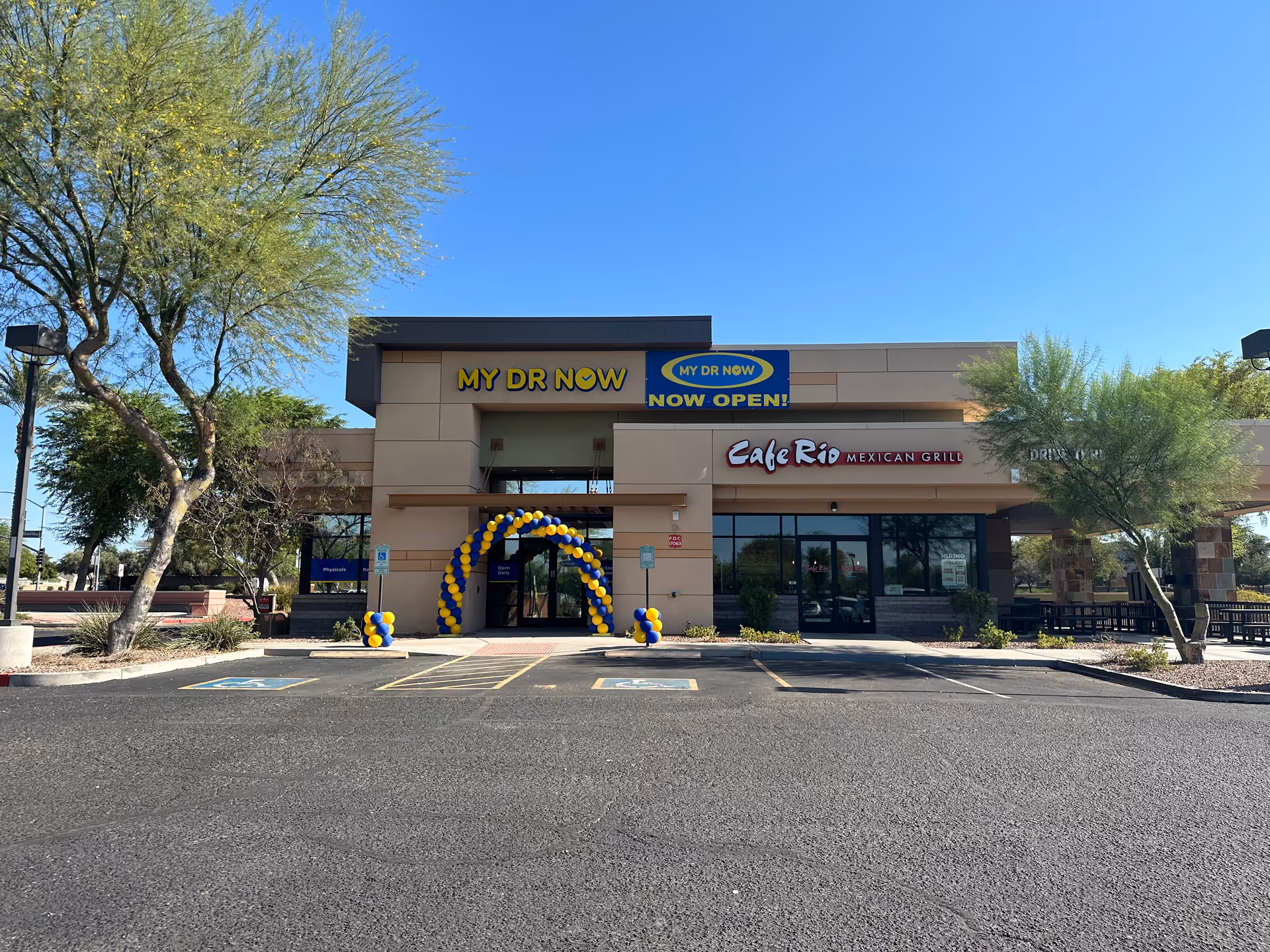 Exterior of a building with MY DR NOW signage, cafe rio, and balloon arch at entrance.