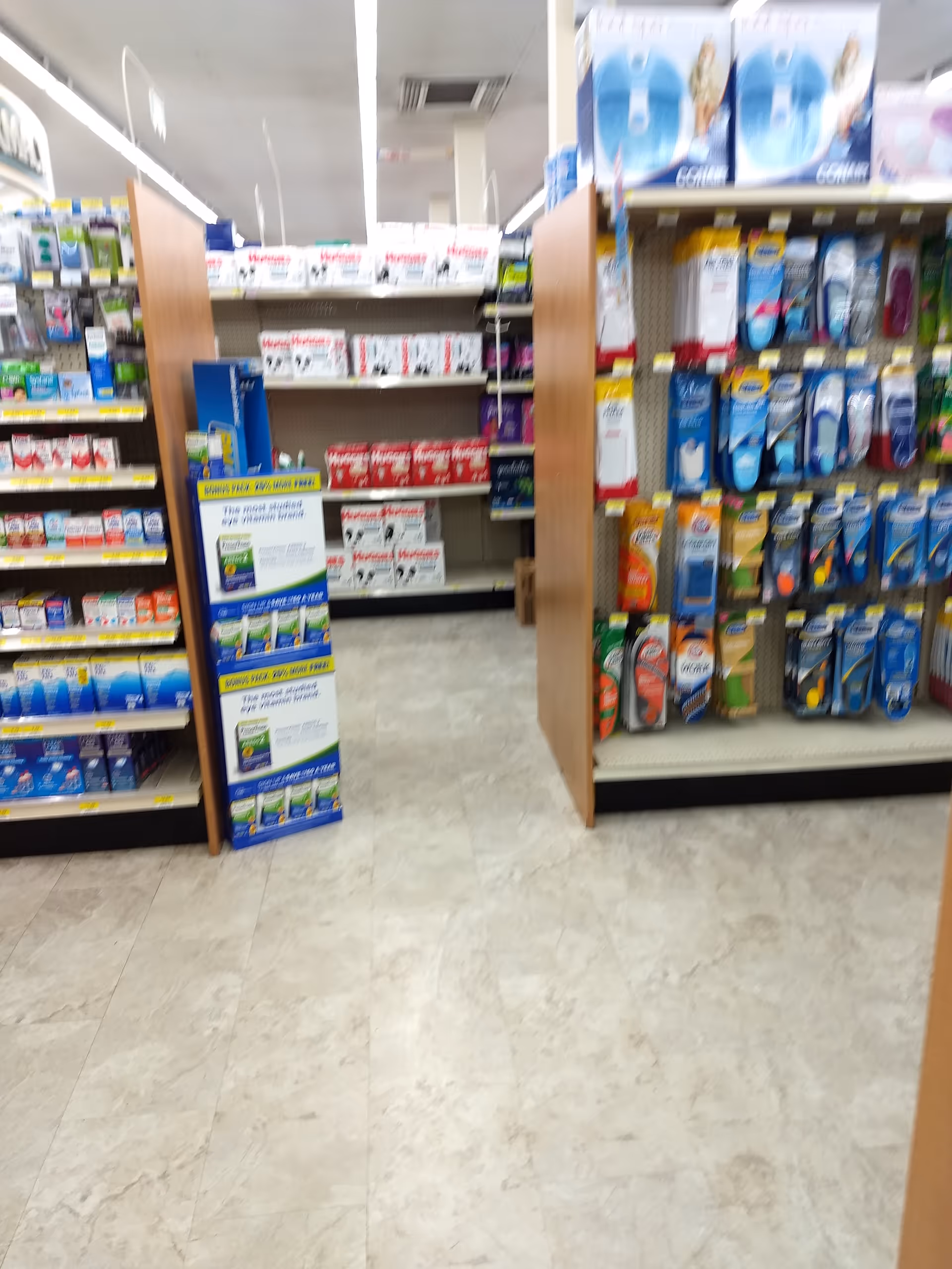 Blurred view of a Discount Drug Mart store aisle with shelves of medications.