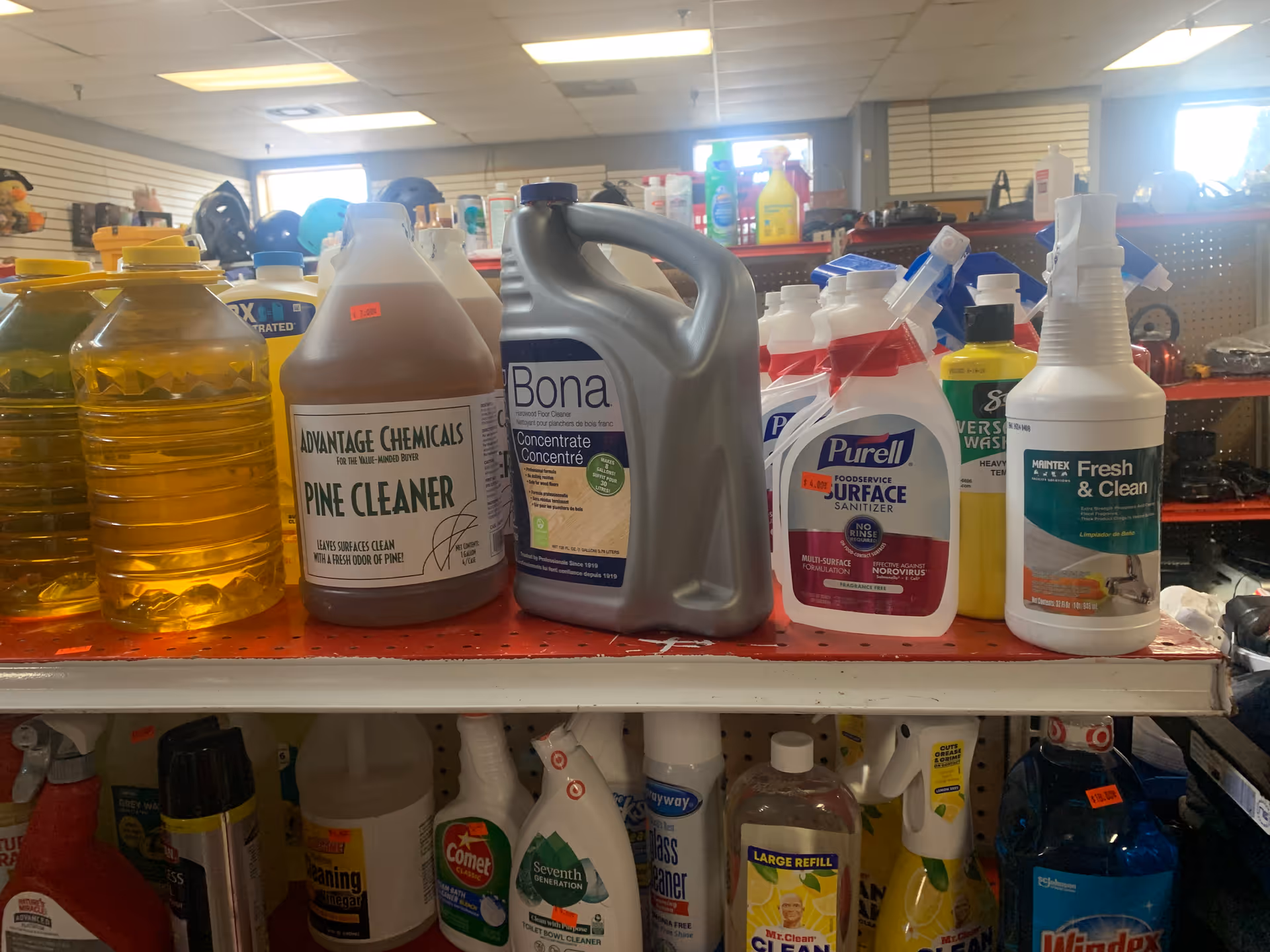 A shelf stocked with cleaning products and detergents in a maintenance area.