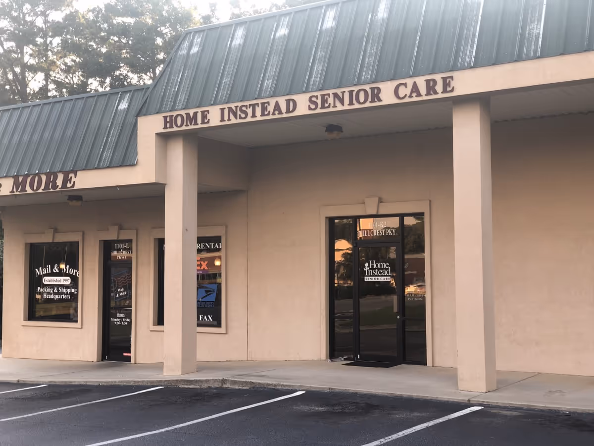 Front exterior of Home Instead Senior Care building with sign, doors, and a parking lot.
