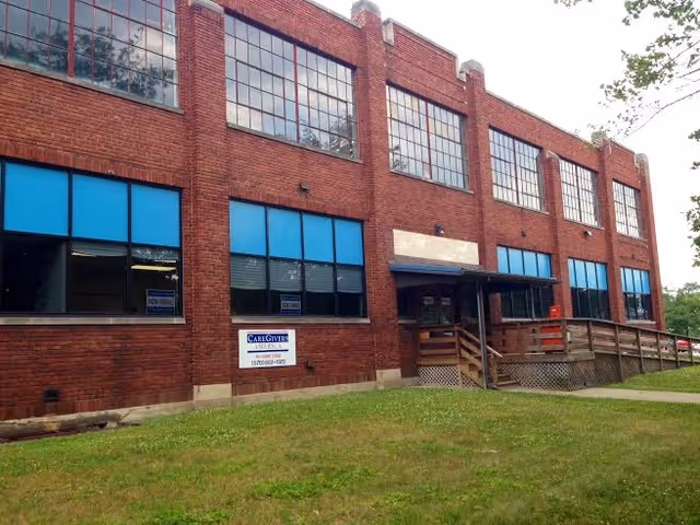 Brick facility for CareGivers America with blue-tinted windows and ramped entrance.