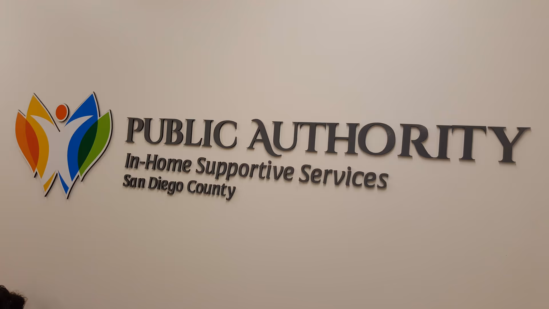 Interior wall featuring Public Authority sign and colorful logo for In-Home Supportive Services.