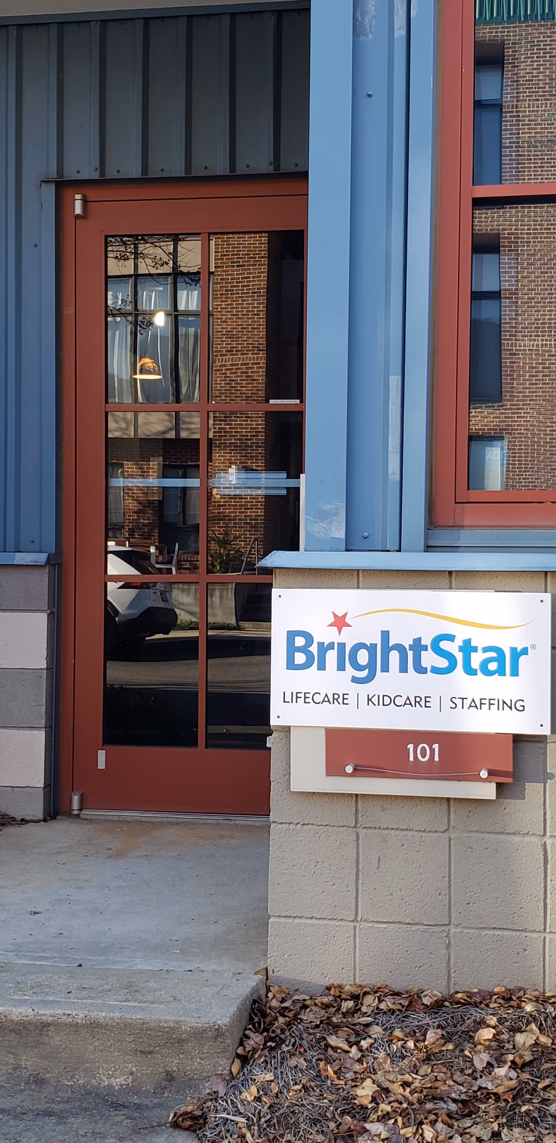The BrightStar Care entrance shows a red door, blue trim, and a front sign.