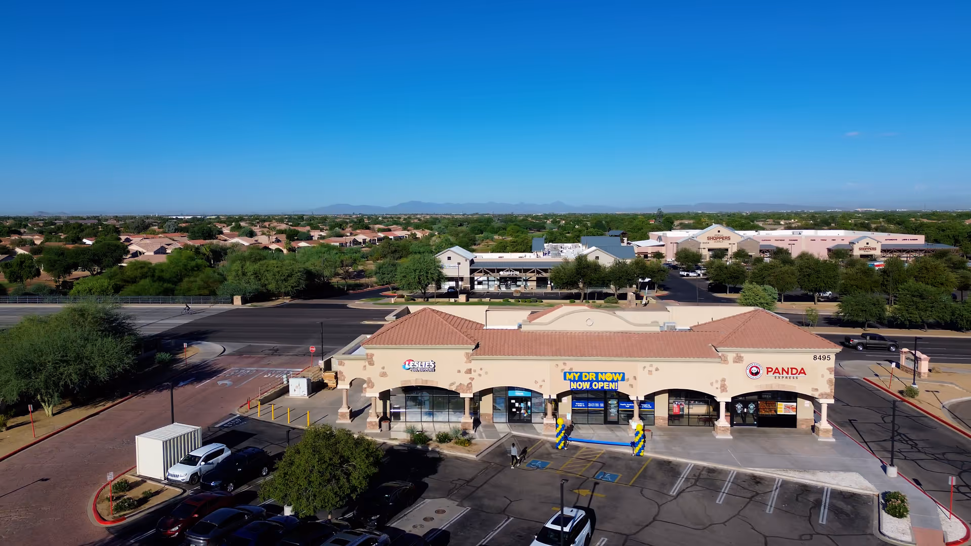 Aerial view of a single-story shopping plaza with MY DR NOW storefronts and a parking lot.