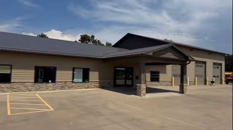 Exterior view of MobilityWorks facility with covered entrance, parking area, and tan siding.